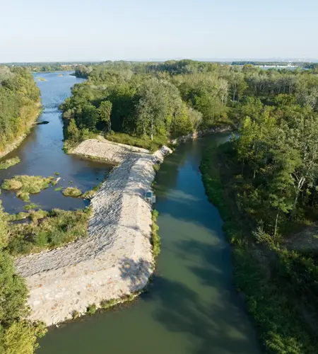 Naturschutzmaßnahmen bei Wasserkraftwerk Altenwörth. Das Bild zeigt das Projektgebiet von oben. Man sieht einen Schutzdamm, Fluss und ein Wäldchen.